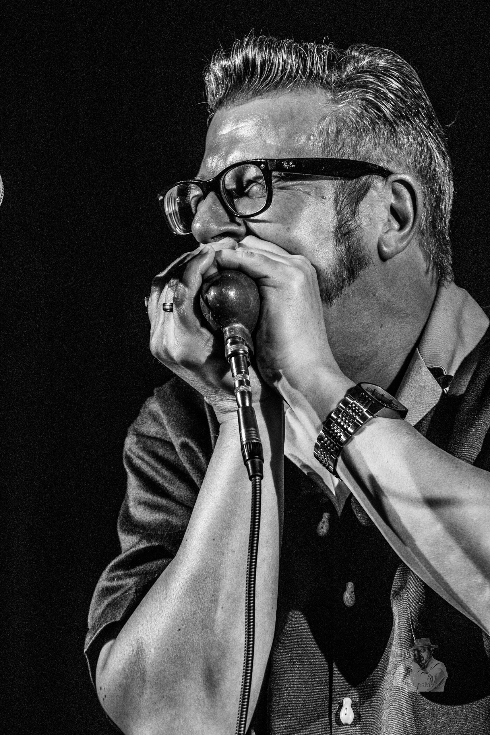 Musiker Dieter Kropp in schwarz weiß der eine Mundharmonika spielt