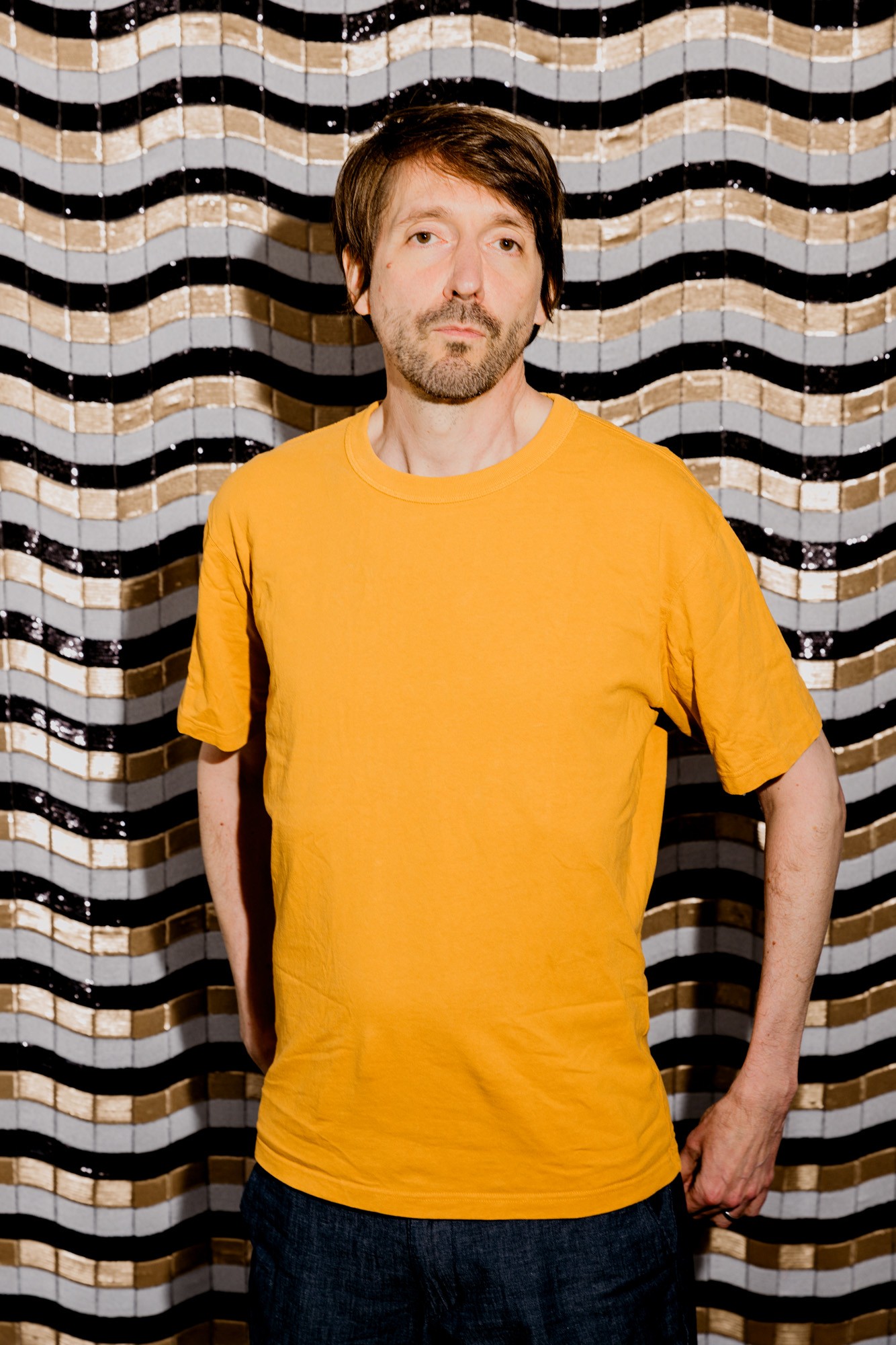 Musiker Hanno Busch in orangem T-Shirt